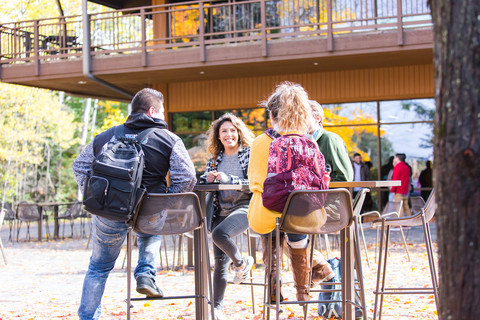 Students sitting at patio in fall