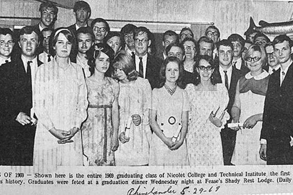 Nicolet College's first graduating class of 1969 posing in formal attire, black and white photo.