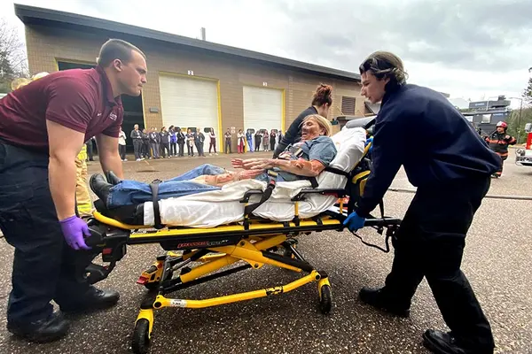 burn victim on stretcher with two emts helping wheel the patient