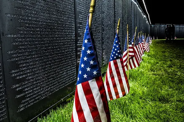 The wall that heals with american flags in front of it