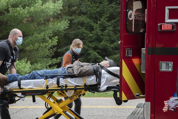 two EMTs loading a patient into a ambulance
