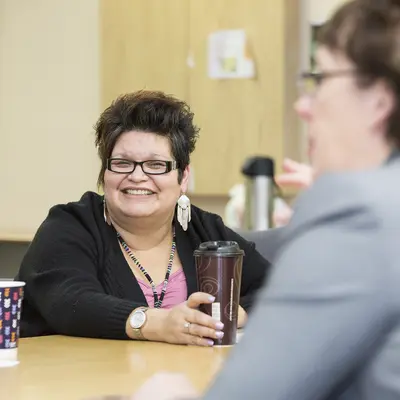 Business Management student in Mole Lake smiling while instructor speaks. 