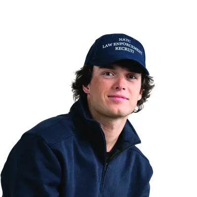 Young man in navy jacket and cap, white background.