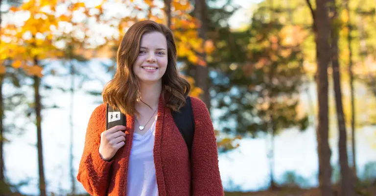female student outside with lake in background
