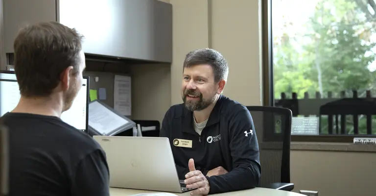 male student meeting with a male admissions rep in an office