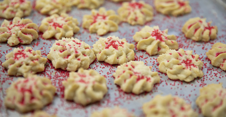 shortbread cookies on a pan with red sprinkles