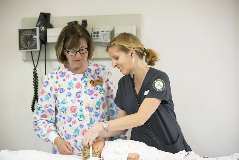Nursing student measuring infant