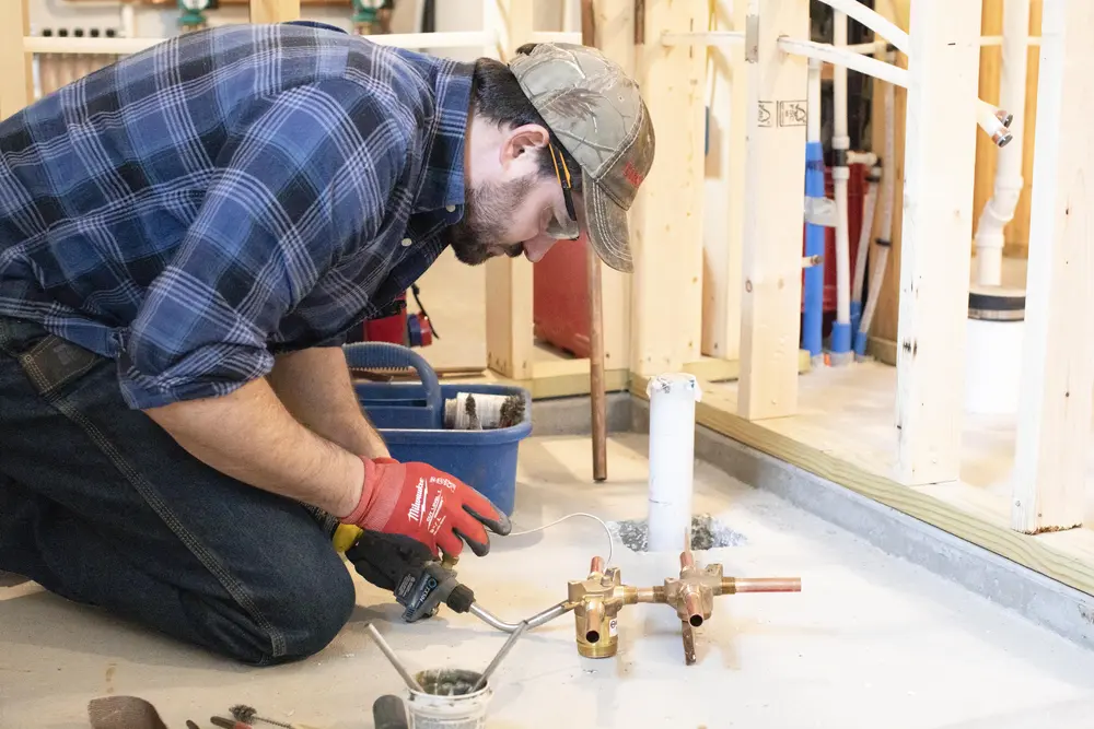 male plumber working on copper pipes