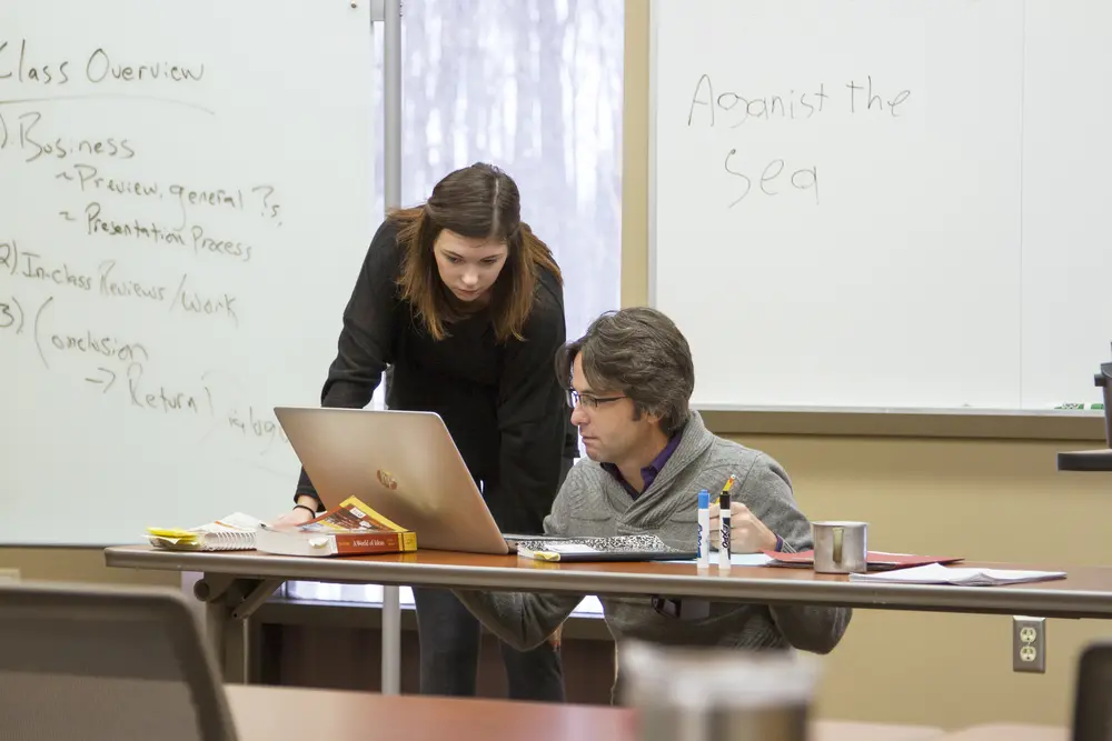 Student and instructor working together with lap top