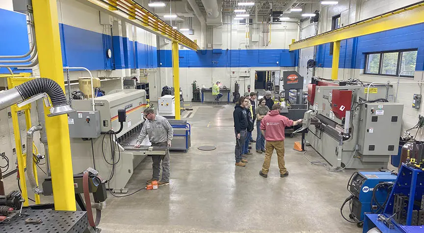 manufacturing lab with students and instructors working on projects