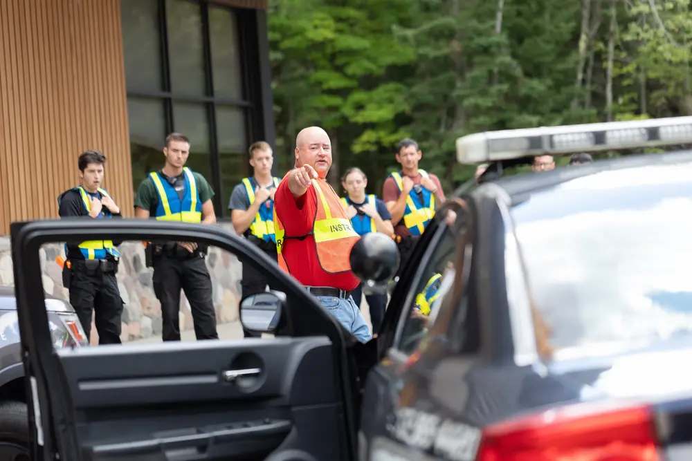 Criminal Justice instructor with students in front of squad car.