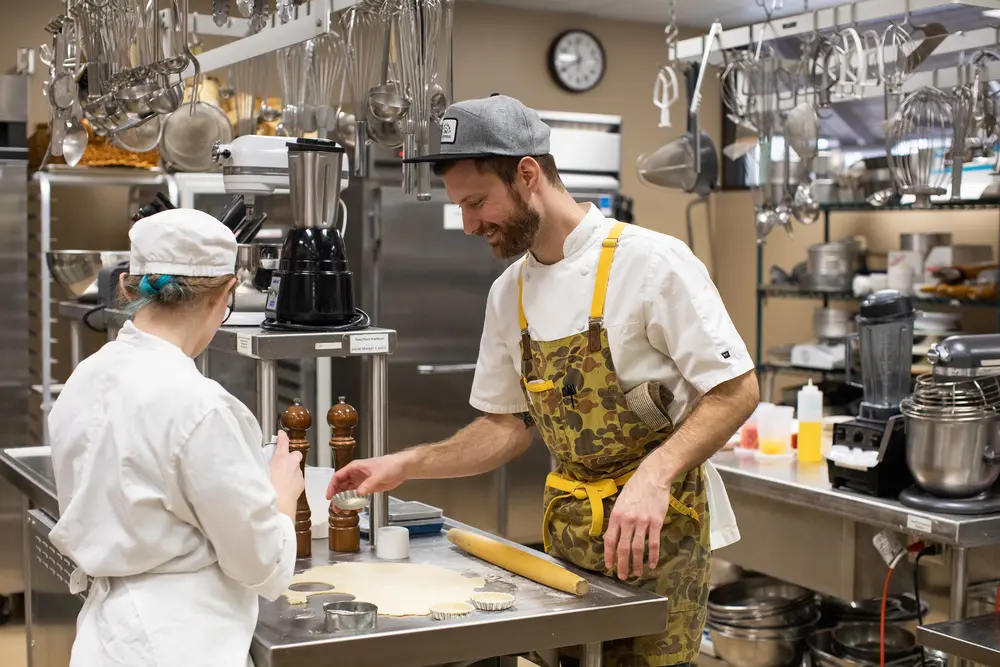 Chefs in a commercial kitchen preparing food together.
