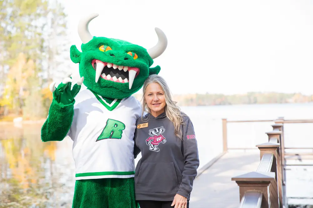 Rhinelander Hodag mascot next to Nicolet College President on a lakeside.