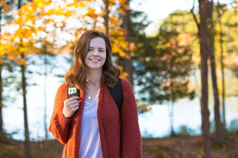 female student outside with lake in background