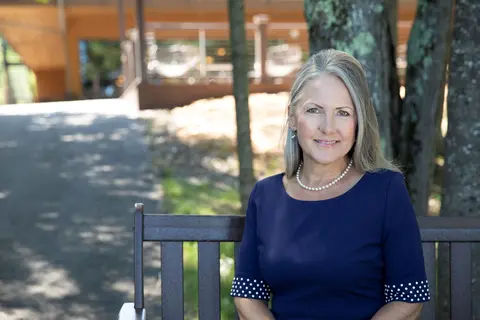 Kate Ferrel, Nicolet President sitting on bench outside in summer