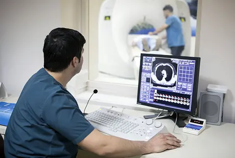 radiography student reviewing an xray on a computer screen