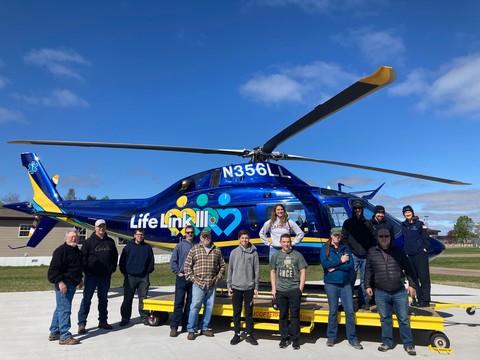 photo of aviation class standing in front of helicopter
