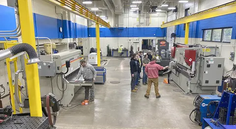 manufacturing lab with students and instructors working on projects