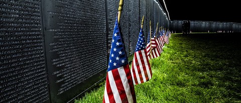 The wall that heals with american flags in front of it