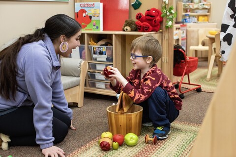 early childhood ed student working with child in childcare center