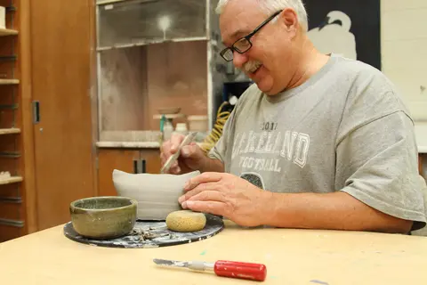 An older learner in a Nicolet College pottery class.