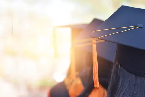 Graduates in caps with an inspirational ray of light.