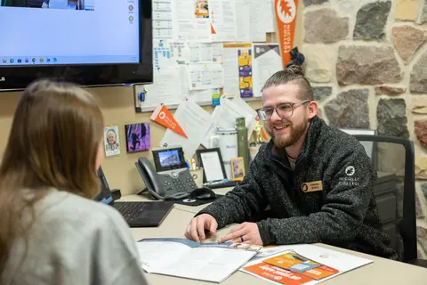 Man and woman having a conversation in an office setting.