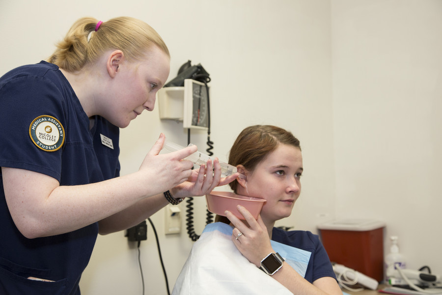 medical assistant student performing ear wash procedure