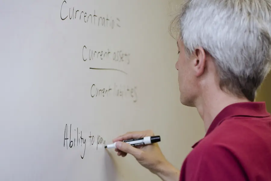 Male instructor writing on white board