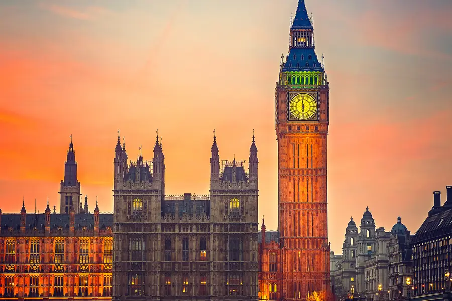 Big Ben and Westminster at sunset, vibrant sky reflections on the Thames.