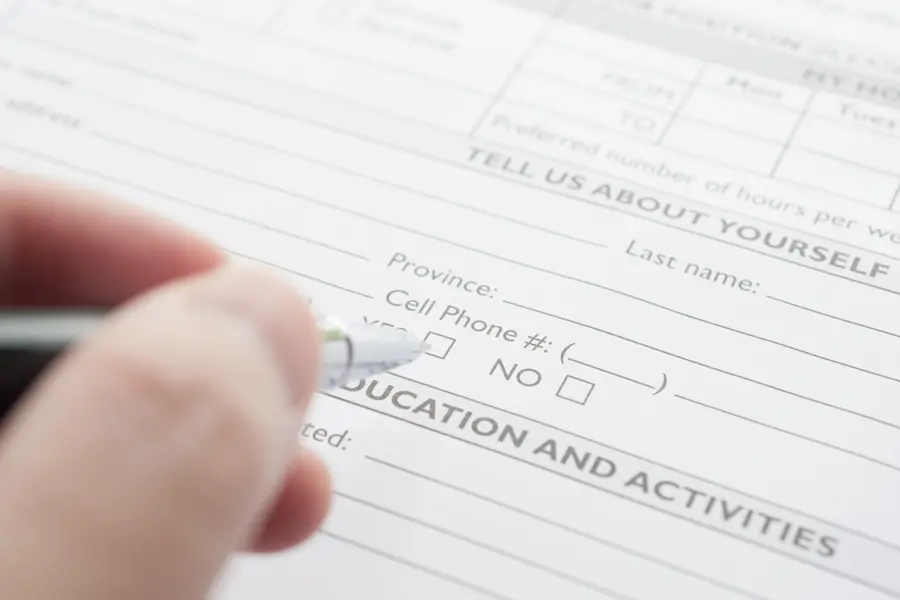 Filling out a printed form with a pen.