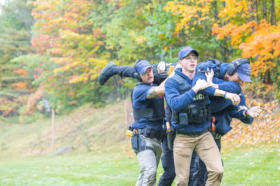 Recruit Academy Students carrying another student for tactical practice.